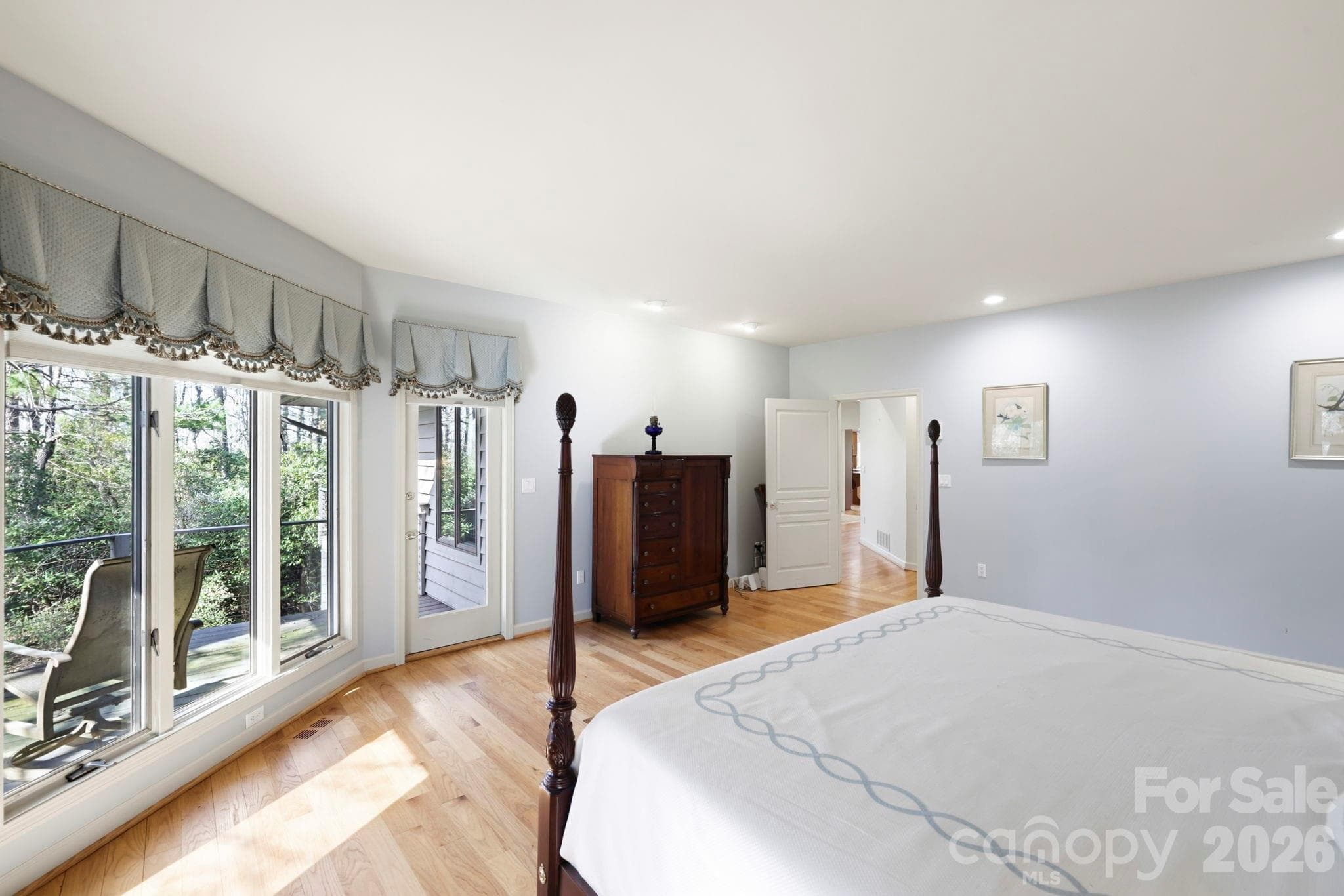 Primary bedroom has entrance to deck overlooking lush woodlands - 100 Elmridge Drive, Flat Rock