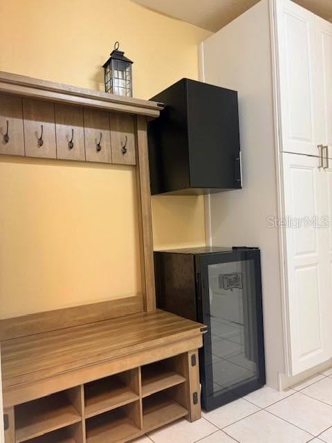 Mudroom with bench seating, coat hooks, storage cabinets, and mini fridge in Lady Lake FL home - 110 CHULA VISTA AVE, LADY LAKE