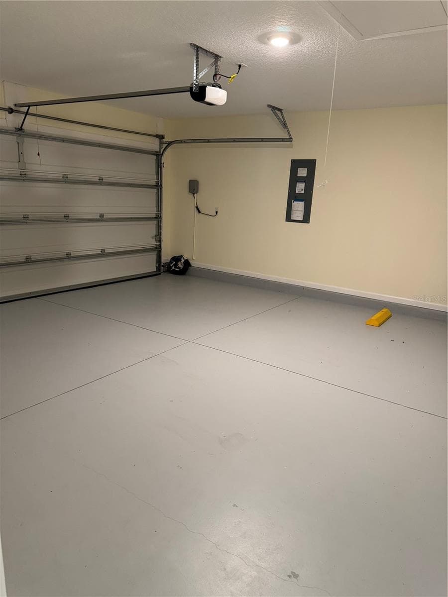 Garage with pull down stairs to attic, walls painted and floor painted - 203 CHESTERWOOD RD, ST AUGUSTINE