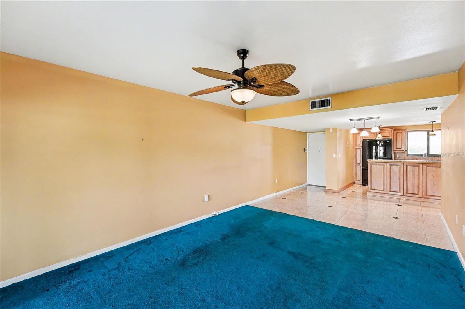 Living room view to Dining area, Kitchen and Front Entry. - 10755 VILLAGE CLUB CIR N #101, ST PETERSBURG