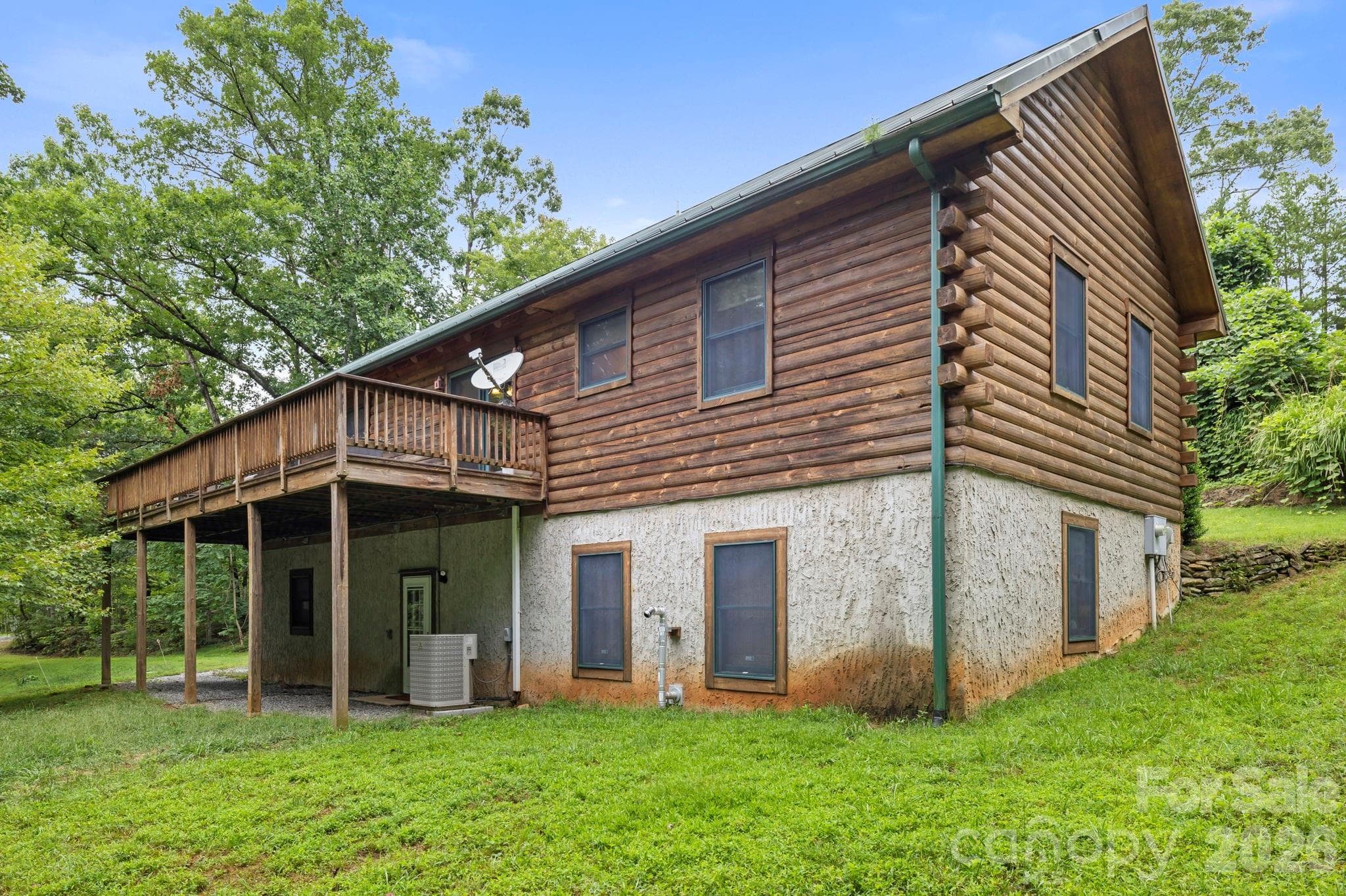 Elevated deck overlooking the wooded surroundings, ideal for outdoor dining or enjoying the natural setting. - 266 Rhododendron Drive, Saluda
