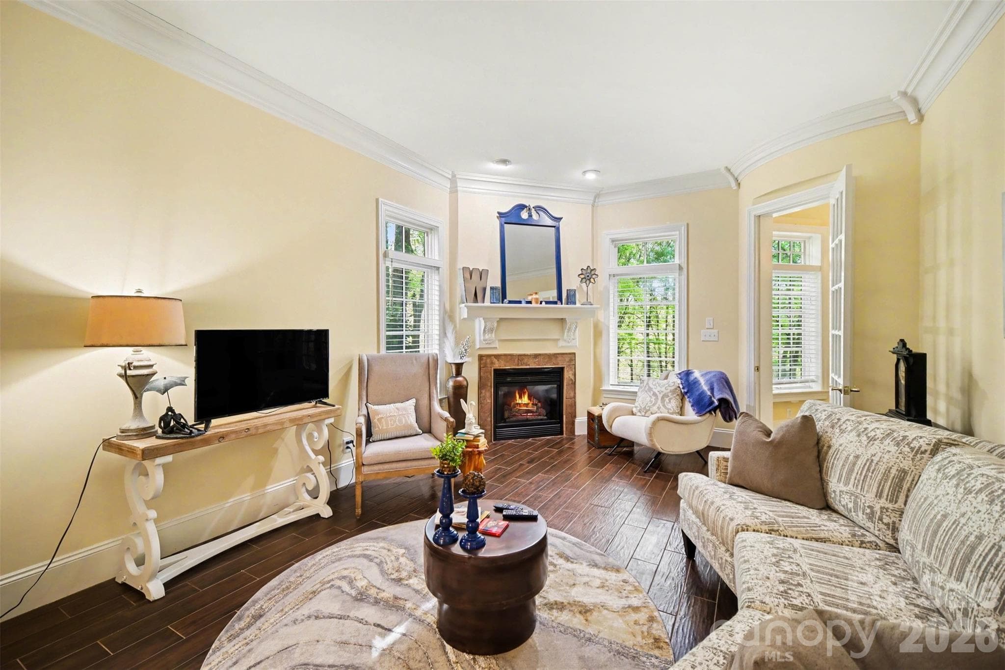 Living room with gas log fireplace and tall windows... - Shelby