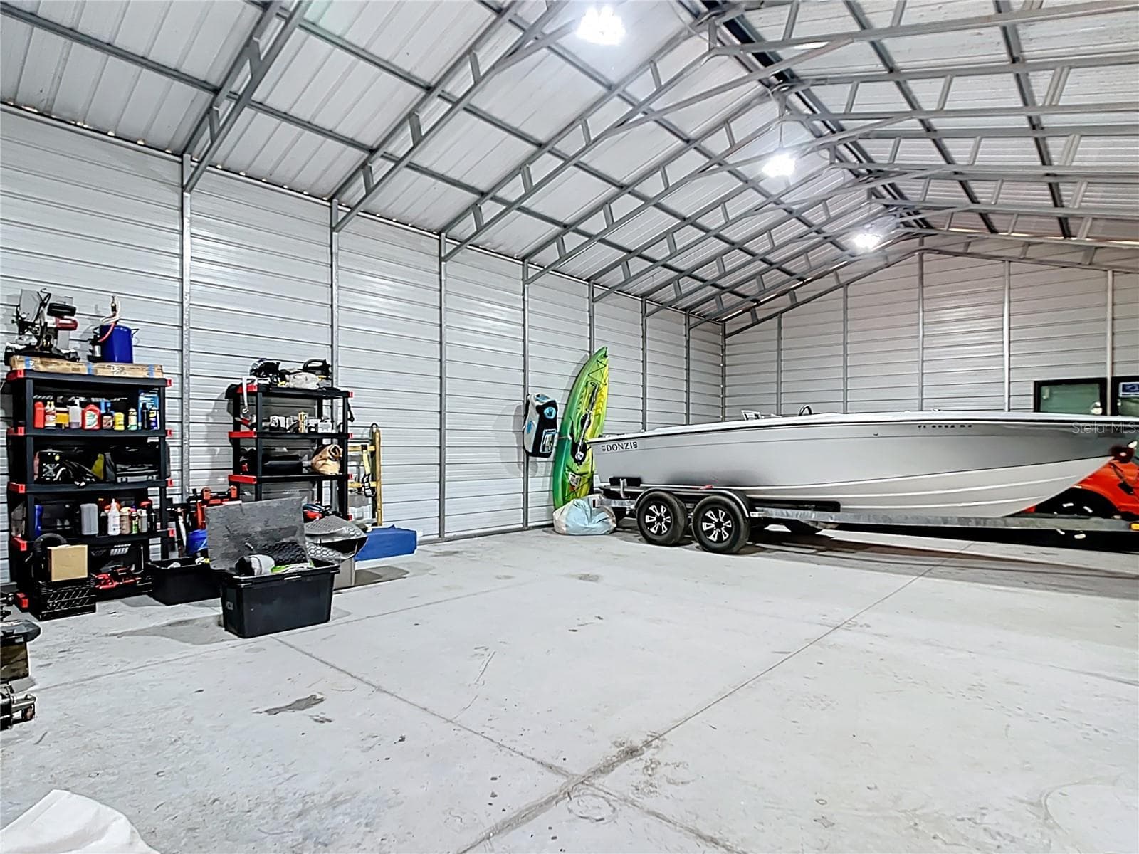 Interior of detached metal workshop with lighting and concrete slab floor - 7374 CIRCLE DR, LADY LAKE