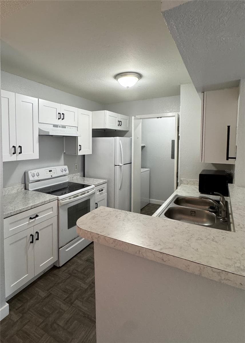 Kitchen with laundry room in the back - 5540 DEVONBRIAR WAY #203, ORLANDO