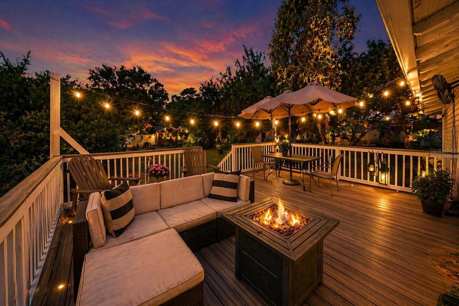 Virtually staged. Back deck at dusk with string lighting and fire feature, ideal for relaxing or entertaining. - 805 E CHELSEA ST, TAMPA