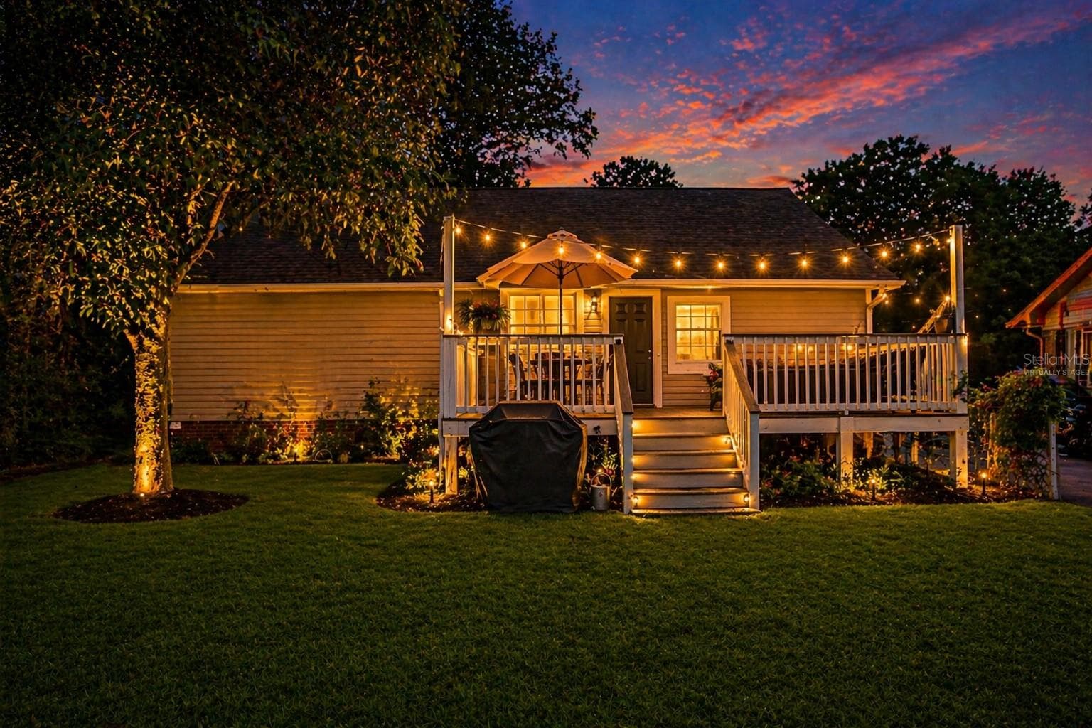 Virtually staged. Backyard at dusk highlighting the outdoor living space and entertaining potential. - 805 E CHELSEA ST, TAMPA