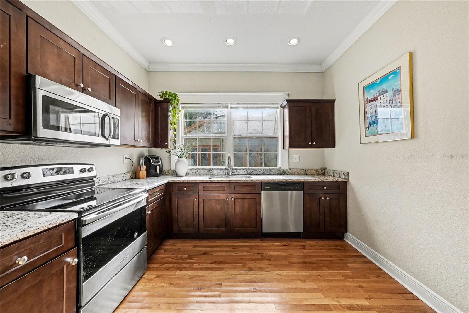 Kitchen with solid wood cabinetry, stainless appliances, and ample counter space. - 805 E CHELSEA ST, TAMPA