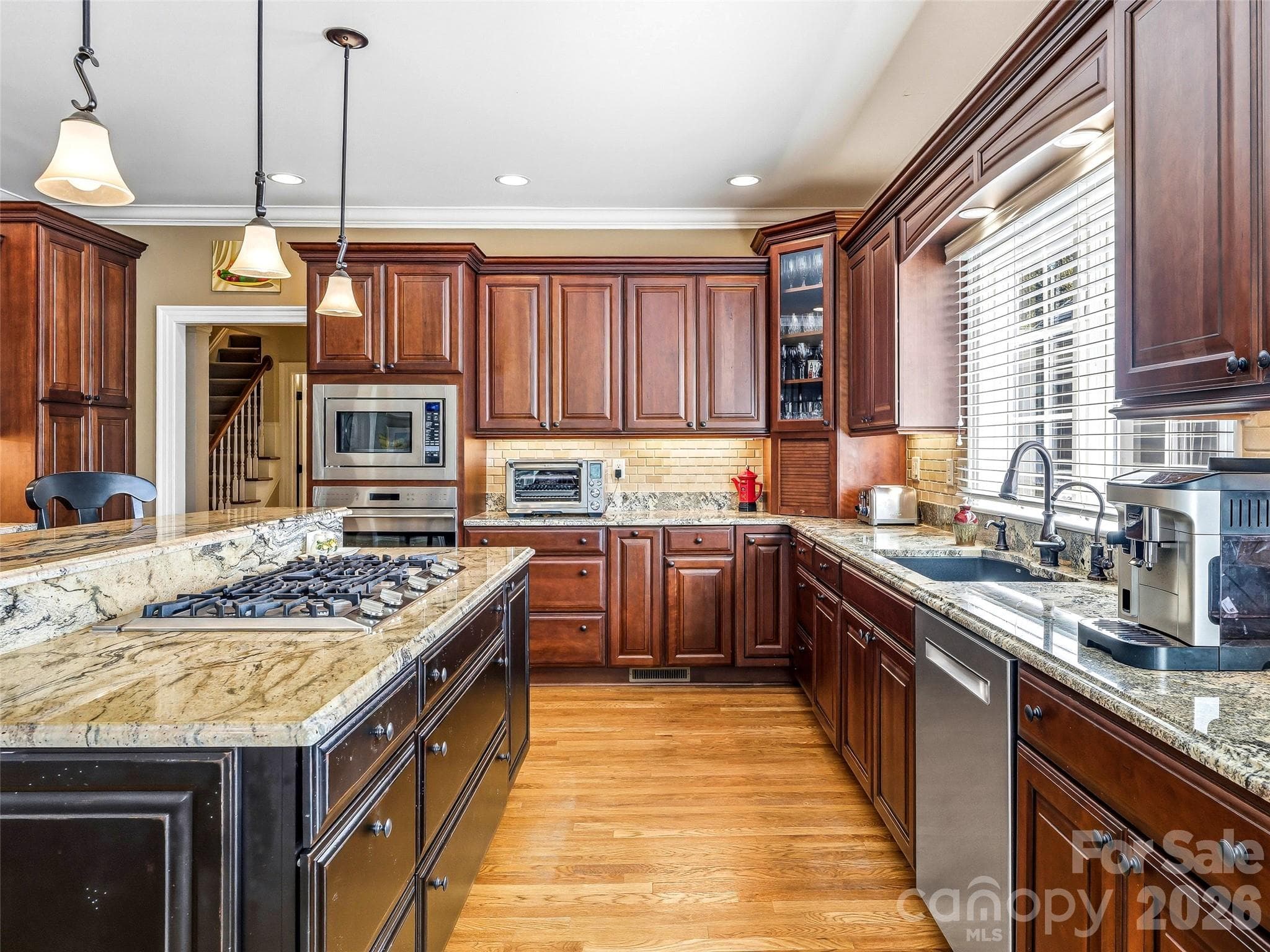 The custom kitchen with gas cooktop will impress any culinary enthusiast. The cooktop features a pop-up downdraft exhaust system, activated with a touch of a button. - 33 Tiverton Lane, Asheville
