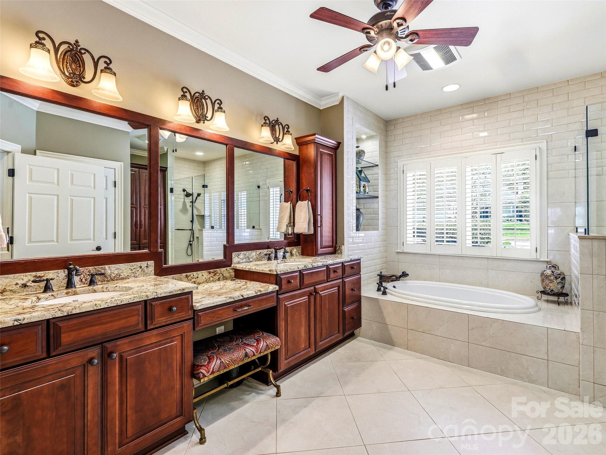 The custom bath offers dual sinks with vanity between, a gracious garden tub, tile shower, and plentiful storage. - 33 Tiverton Lane, Asheville