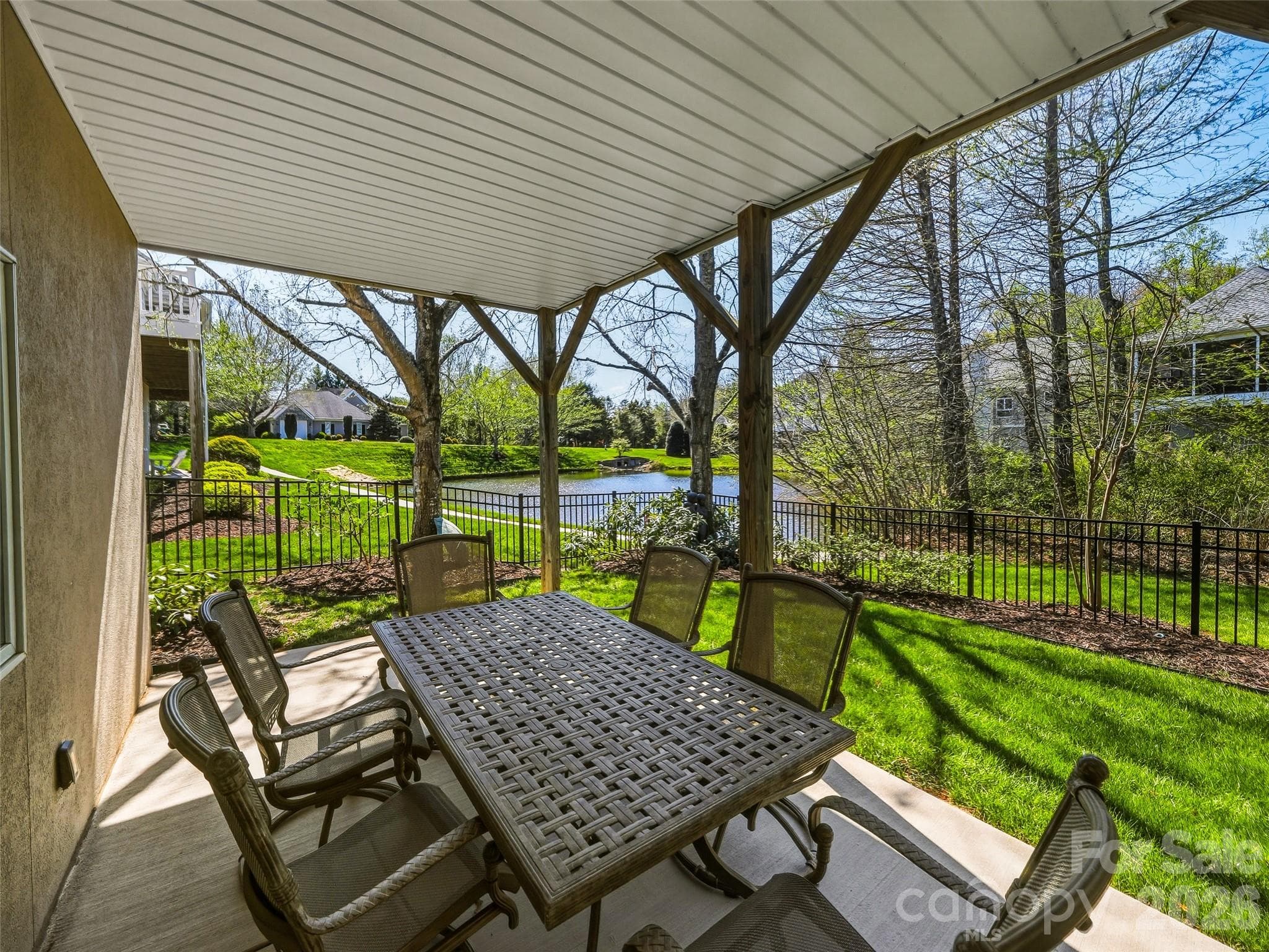 The patio under the all-season porch provides a great covered entertainment area with view of the pond beyond. - 33 Tiverton Lane, Asheville