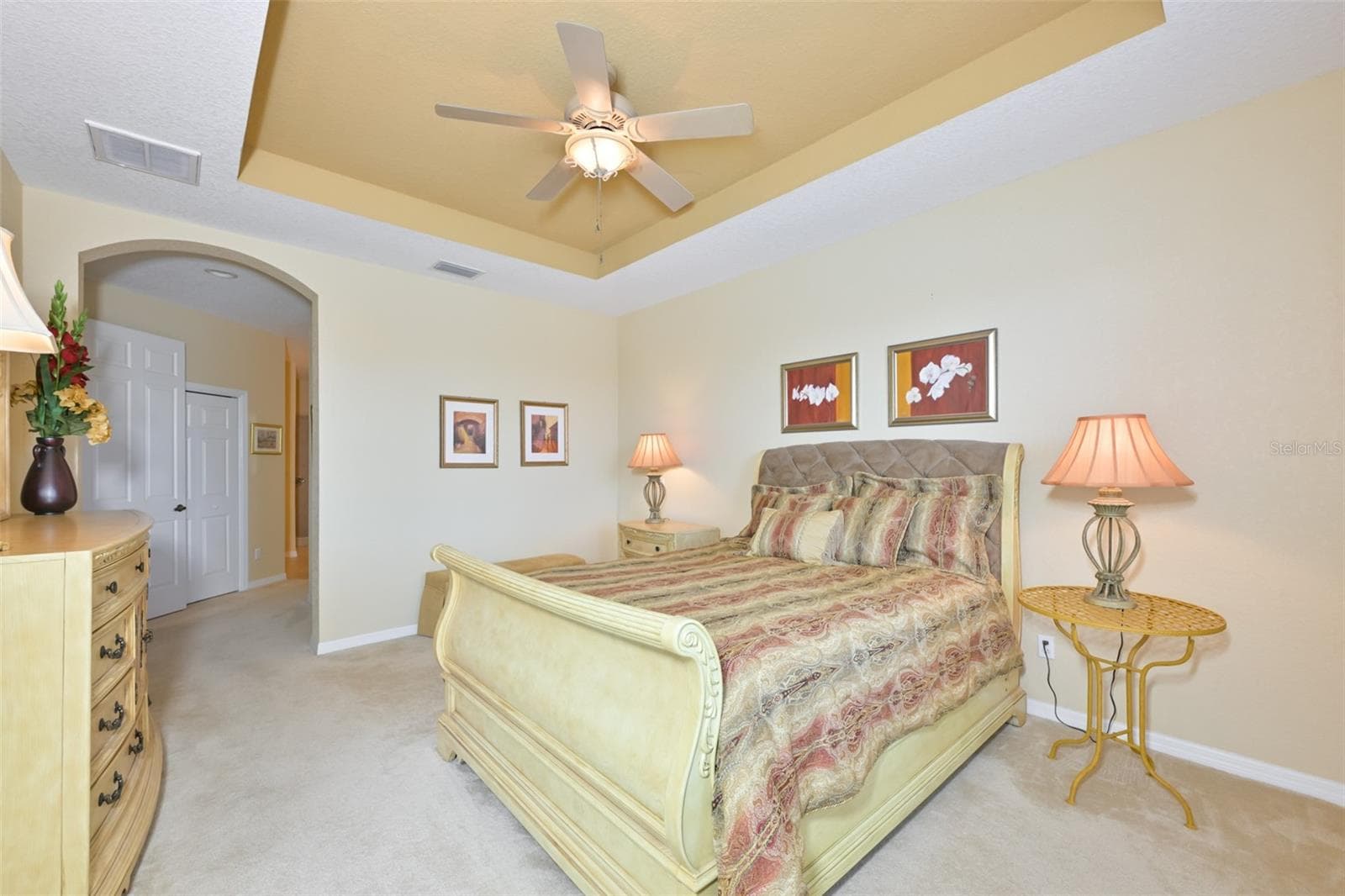 Main bedroom with trey ceiling, tastefully decorated furniture, sleigh bed, dresser, side tables and lamps. - 1330 EMERALD DUNES DR, SUN CITY CENTER