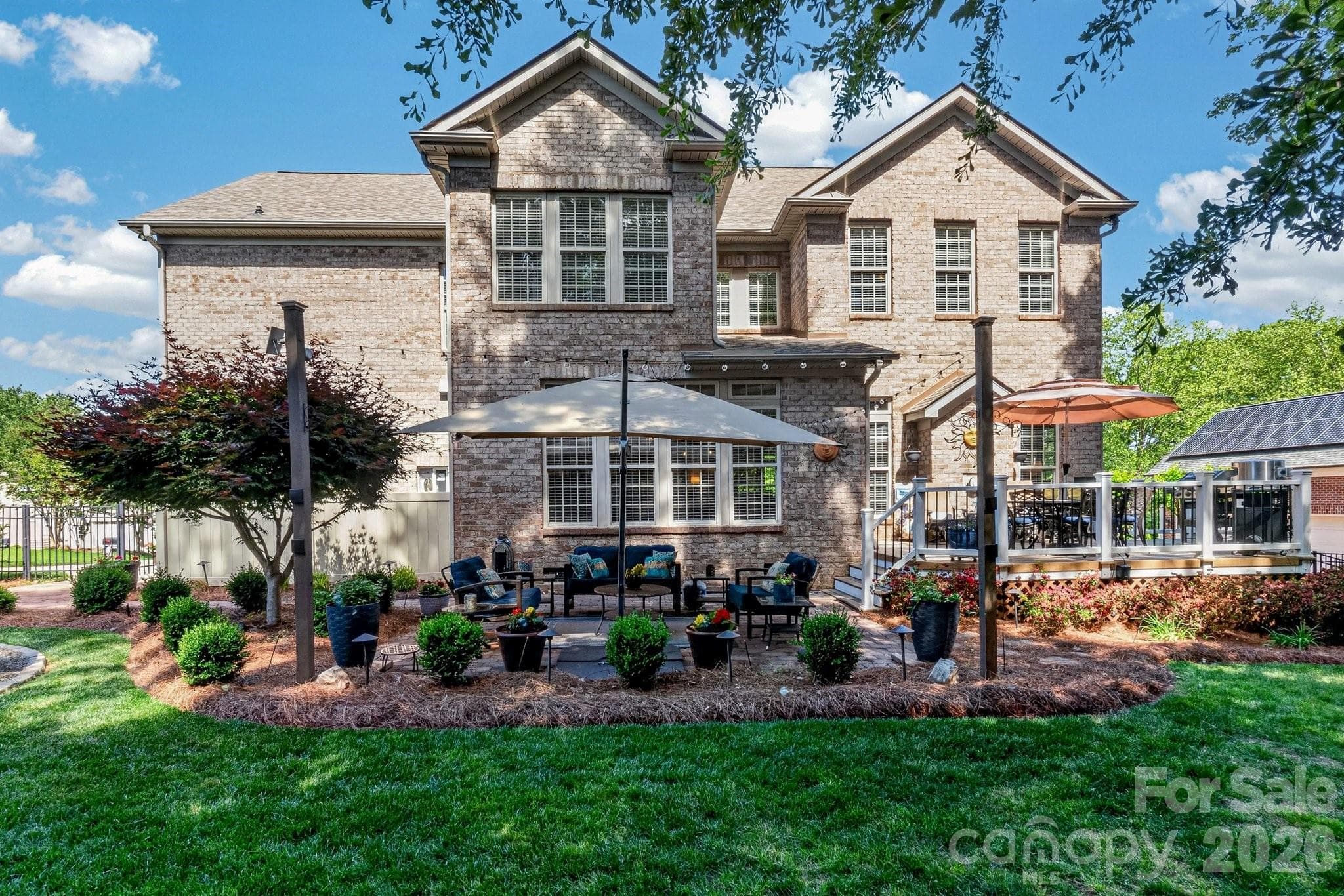 Daytime view of this stunning backyard with an outdoor seating area with a firepit and outdoor grilling/eating area off the kitchen. - Stanley