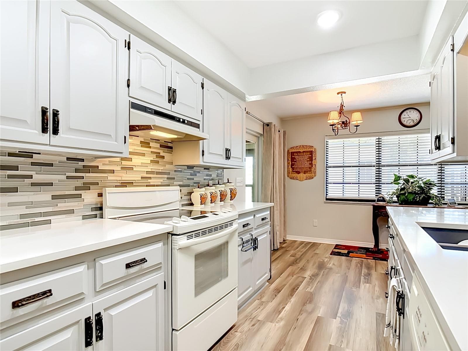Stylish and neutral kitchen with wood cabinets, white appliances and quartz countertops - 17819 PALM ST, UMATILLA