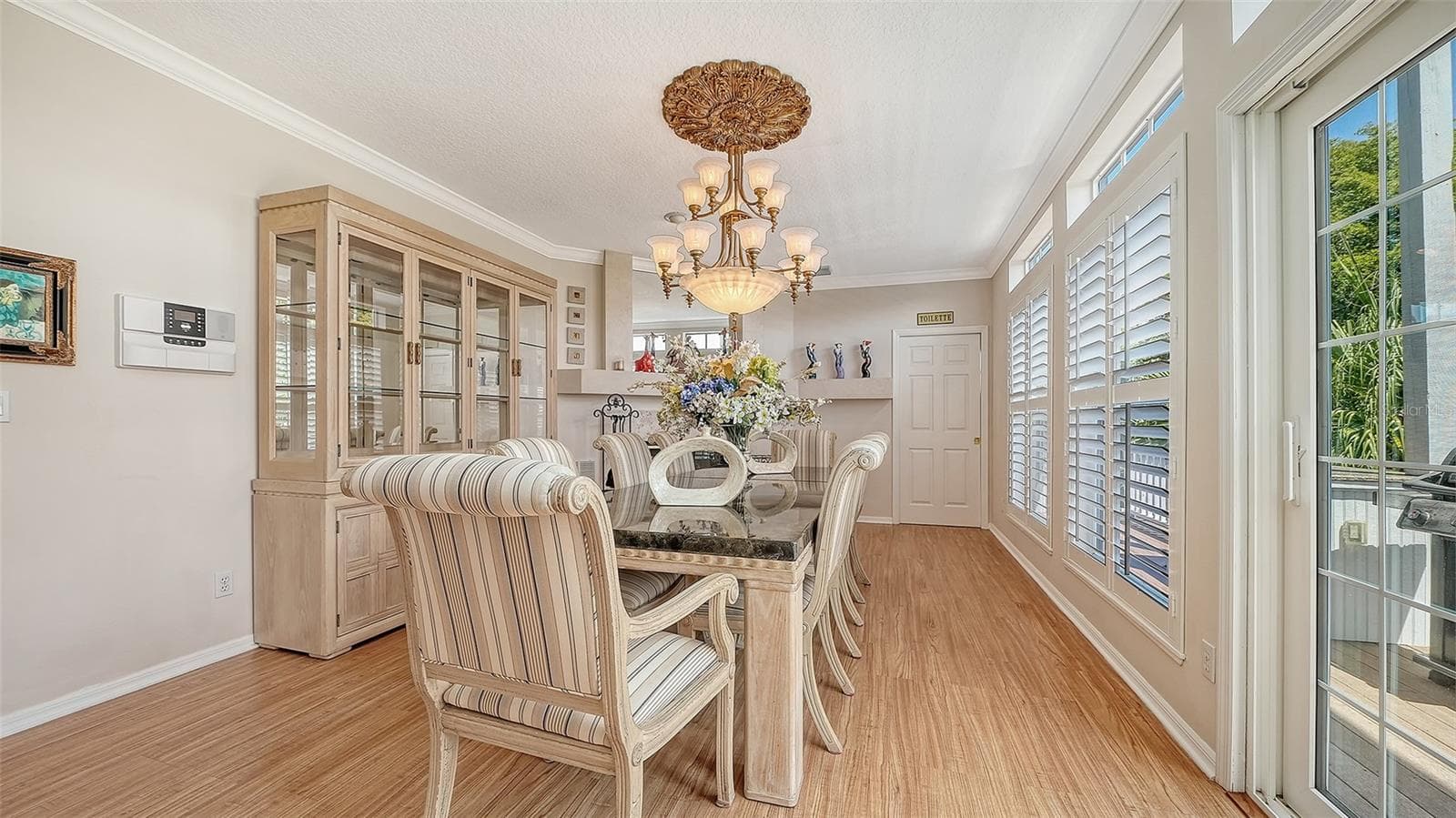 Electric fireplace graces an oversized dining room with complimentary plantation shutters. - 3040 GULF OF MEXICO DR #3, LONGBOAT KEY