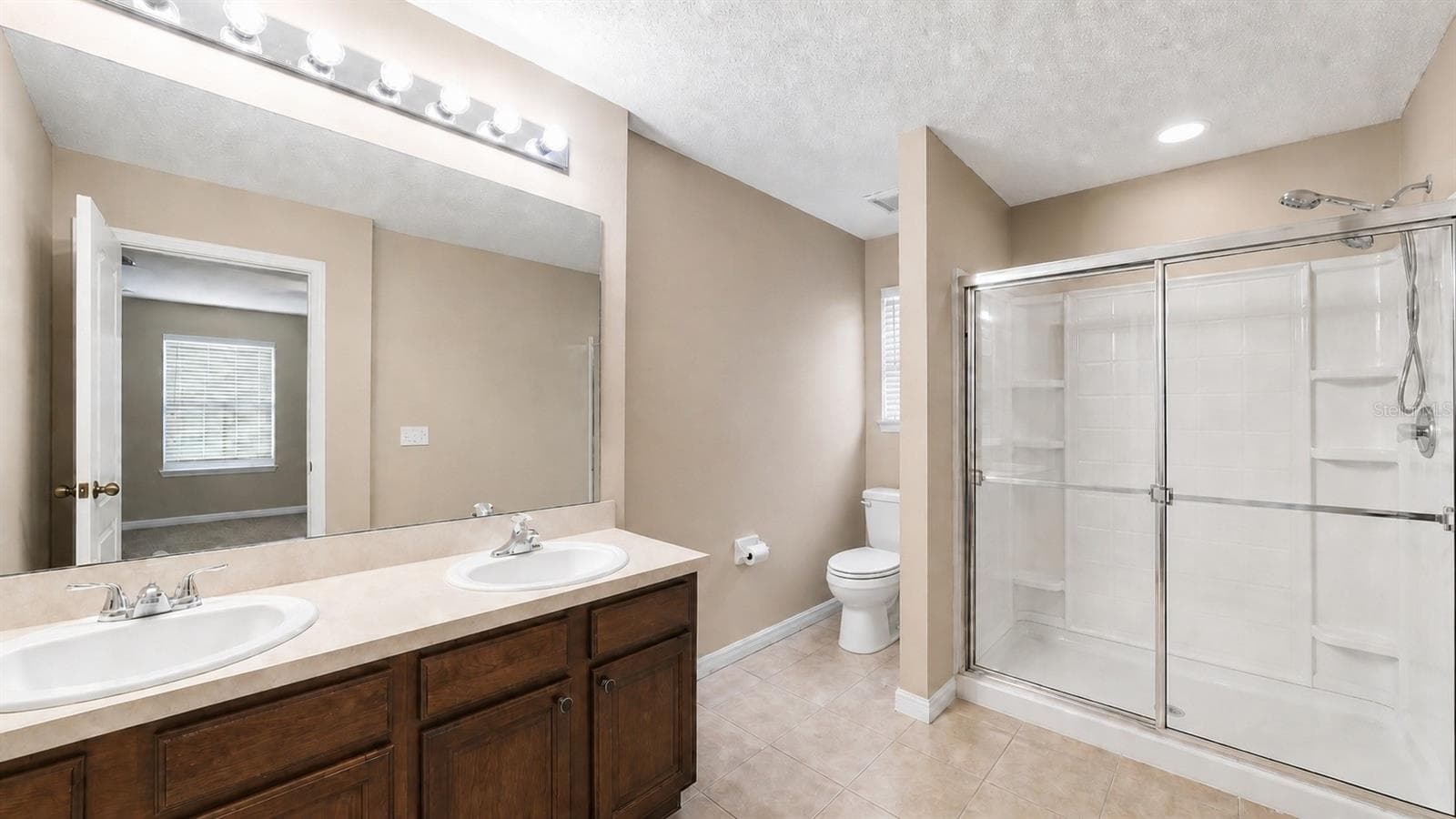 Walk-in shower and dual vanities in the primary bathroom - 4116 ORANGE TREE CT, ST CLOUD