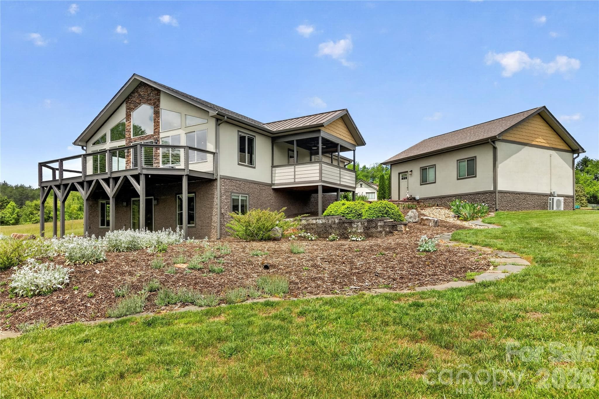 The thoughtfully designed outdoor landscaping enhances the property while incorporating functional drainage solutions. - 141 Round Top Circle, Mills River