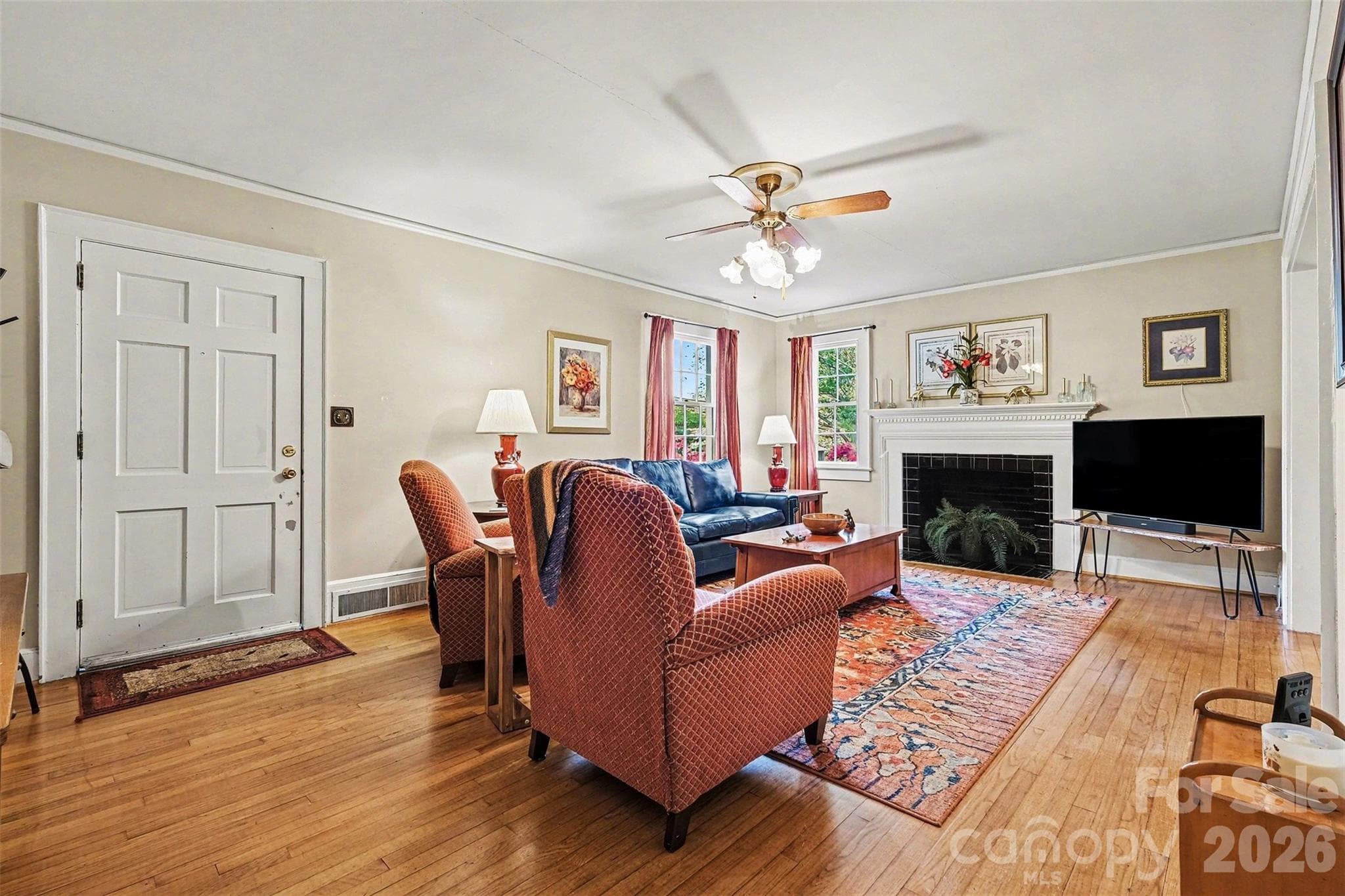 You are greeted by this large living room with neutral paint and hardwood floors. - Shelby