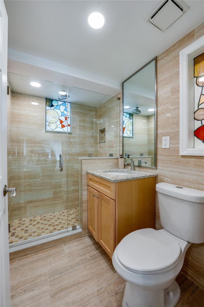 Clean and modern bathroom featuring a shower, large vanity mirror, and updated fixtures that maintain the property’s refreshed aesthetic. - 935 S ATLANTIC AVE #165, DAYTONA BEACH