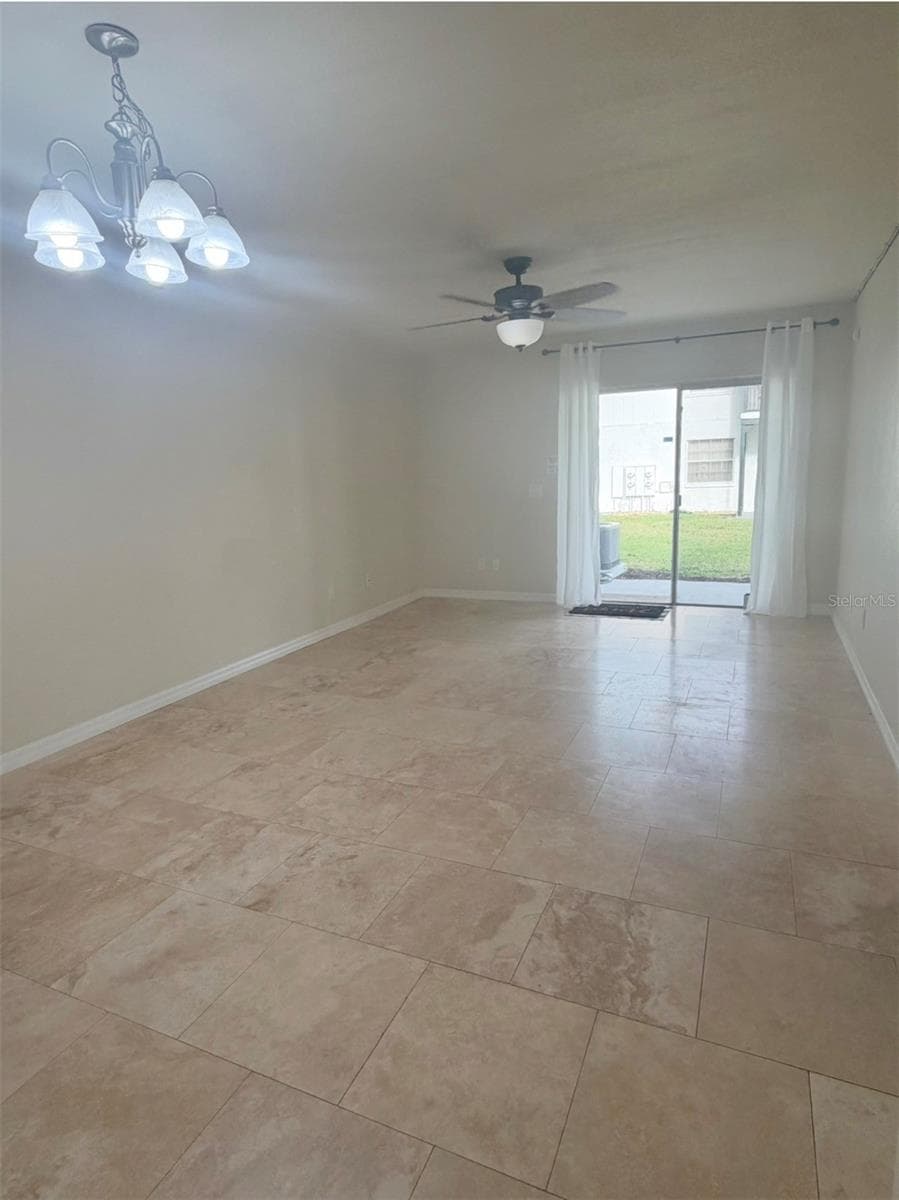 The living room is 20x12 and features travertine floors, a lighted ceiling fan, and sliding doors to the screened-in back patio. - 3815 N OAK DR #G71, TAMPA