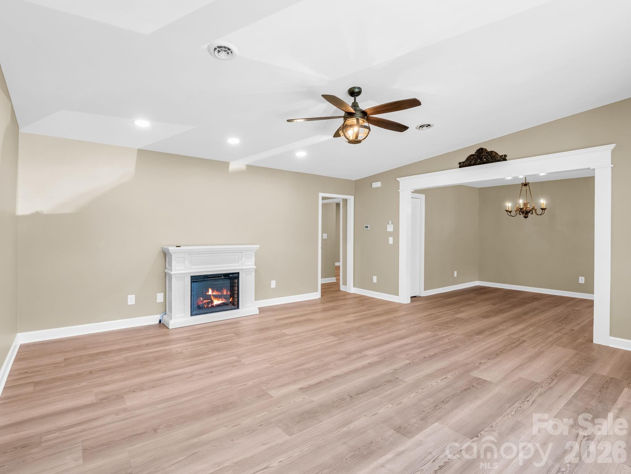 The living room with a new electric fireplace and ceiling fan/light is open to the dining room on the right. - 44 Jervey Road, Tryon