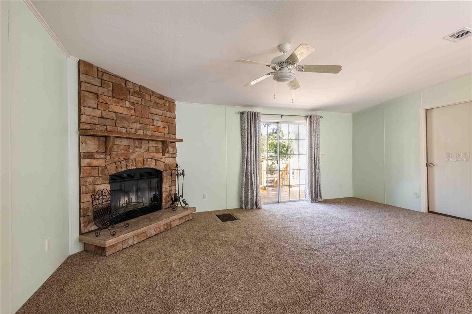 Great room with wood burning fireplace. Door on the right leads to the laundry room. - 14221 HURRICANE DR, WEEKI WACHEE