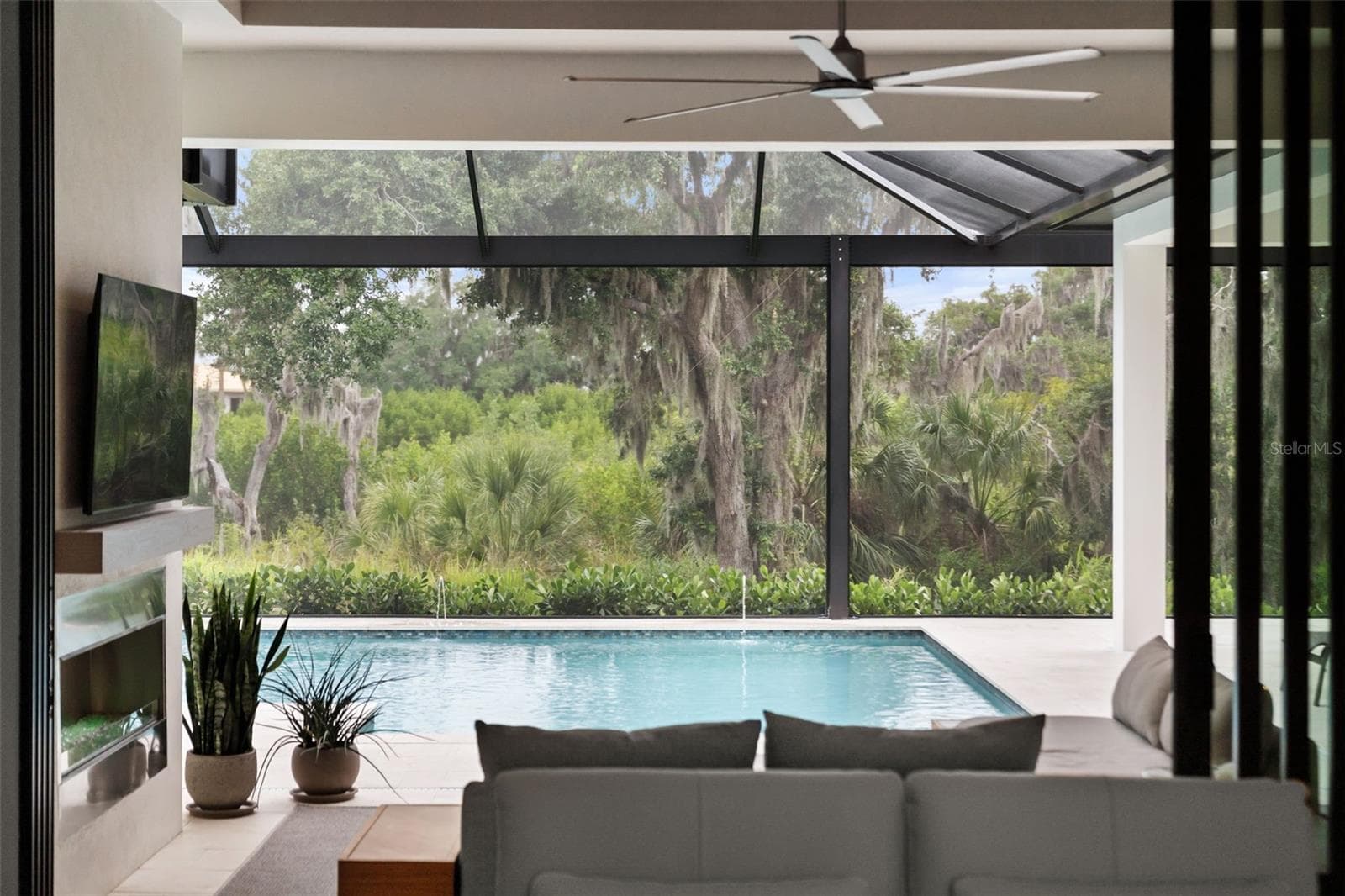 The impact-glass doors slide open to combine the indoor and outdoor living spaces. - 11721 RIVE ISLE RUN, PARRISH