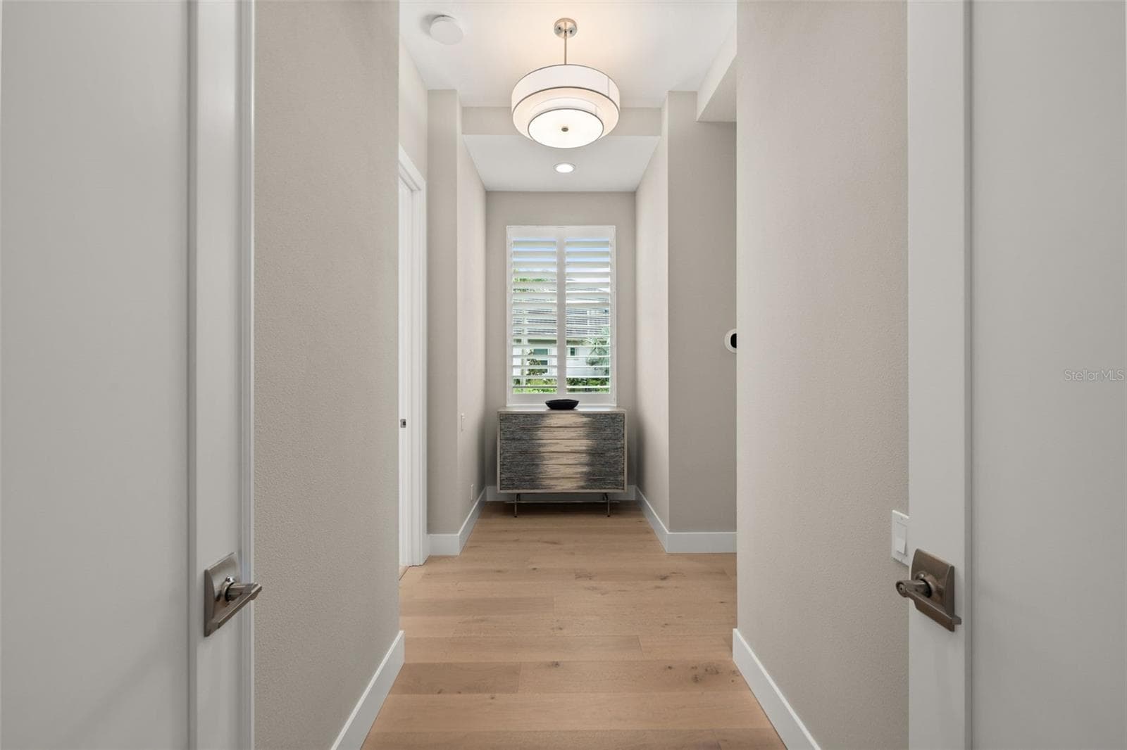The entry way to the primary suite has double doors, beautiful lighting and a window overlooking the beautifully landscaped yard. - 11721 RIVE ISLE RUN, PARRISH