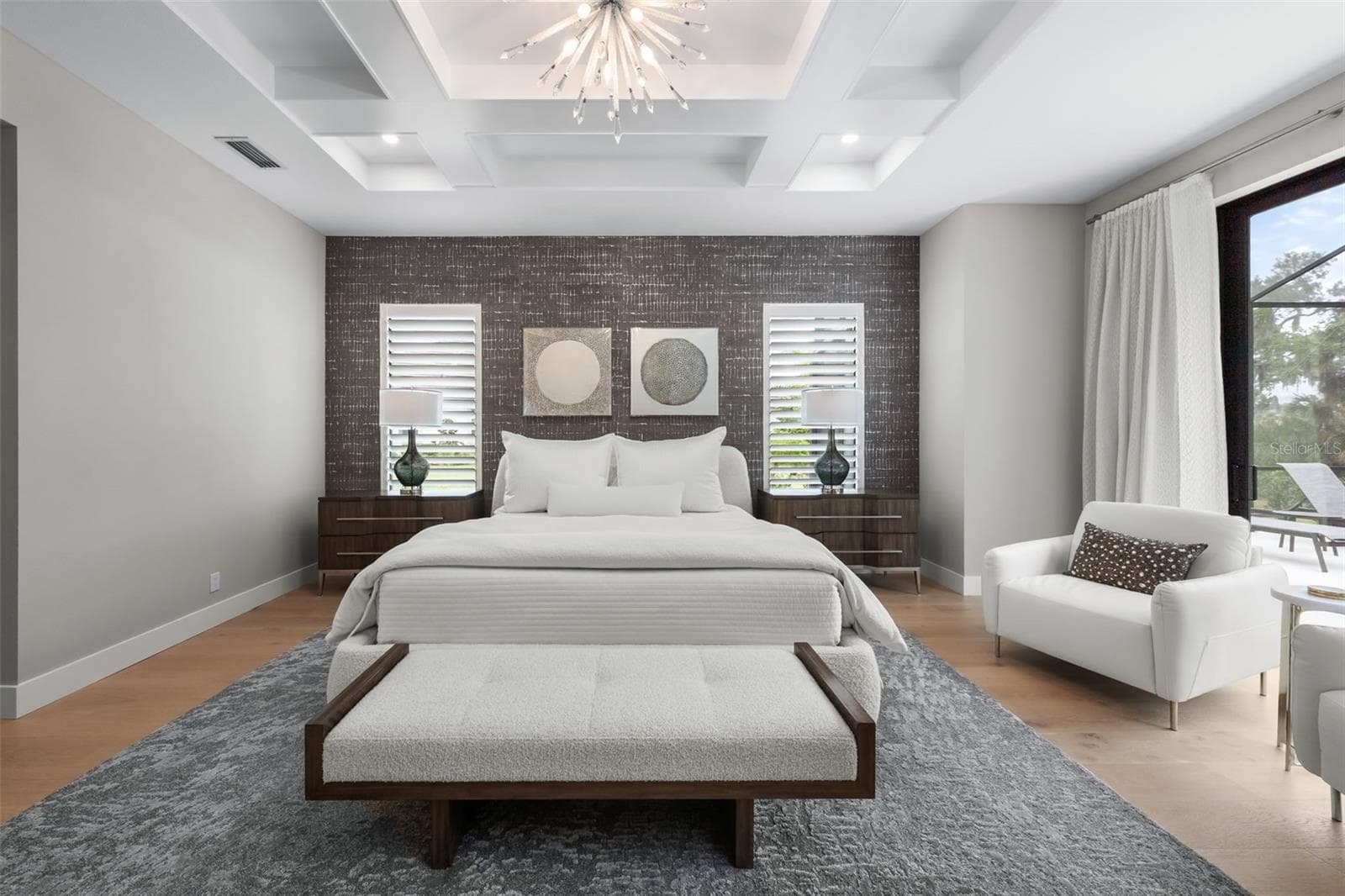 Coffered ceilings with recessed lighting, designer wallpaper accents, and an elegant chandelier create a calming yet sophisticated atmosphere. - 11721 RIVE ISLE RUN, PARRISH
