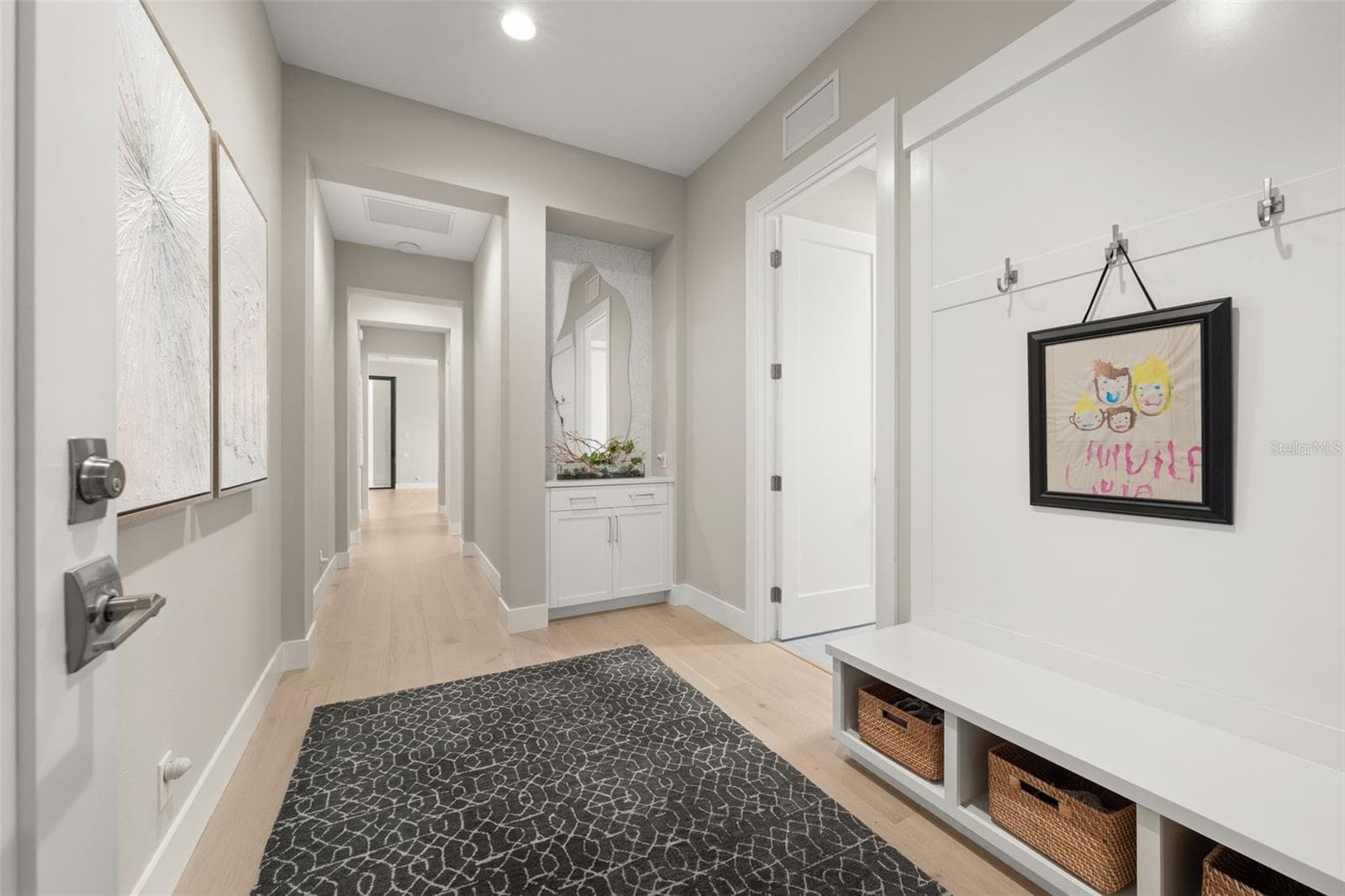 The garage entry way has built-in cabinetry and bench with hooks and storage bins. - 11721 RIVE ISLE RUN, PARRISH