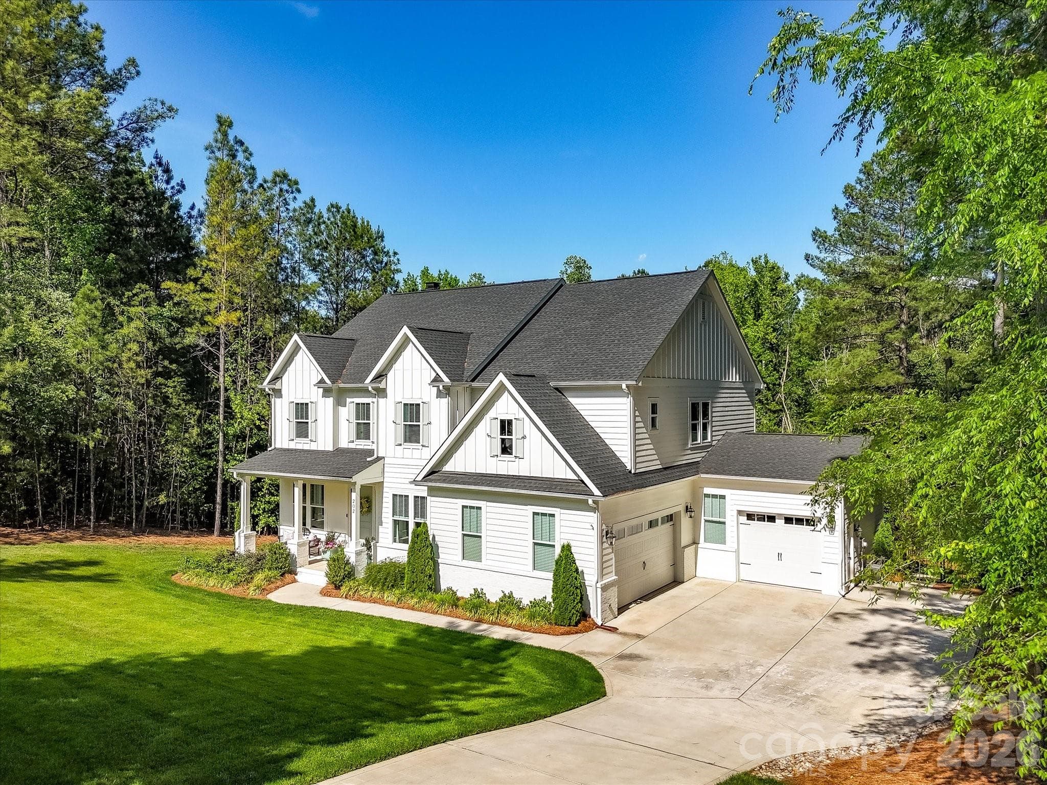 Incredible curb appeal meets timeless style in this stunning home featuring a durable fiber cement exterior, welcoming front porch, 3 car garage, manicured landscaping, and peaceful wooded surroundings. - Troutman