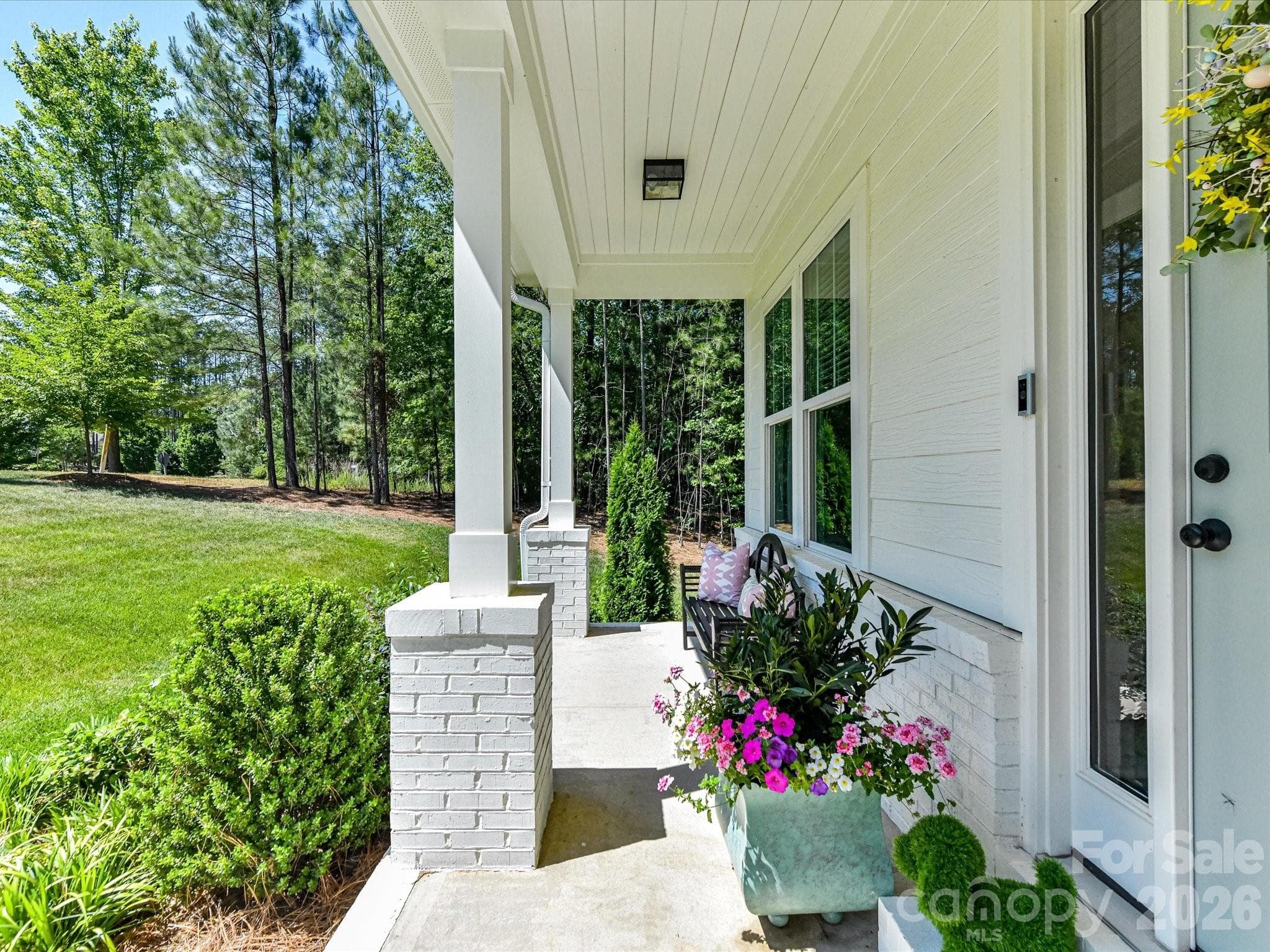 Welcoming front entry features a covered porch, elegant architectural details, and beautifully maintained landscaping that create warm curb appeal from the moment you arrive. - Troutman