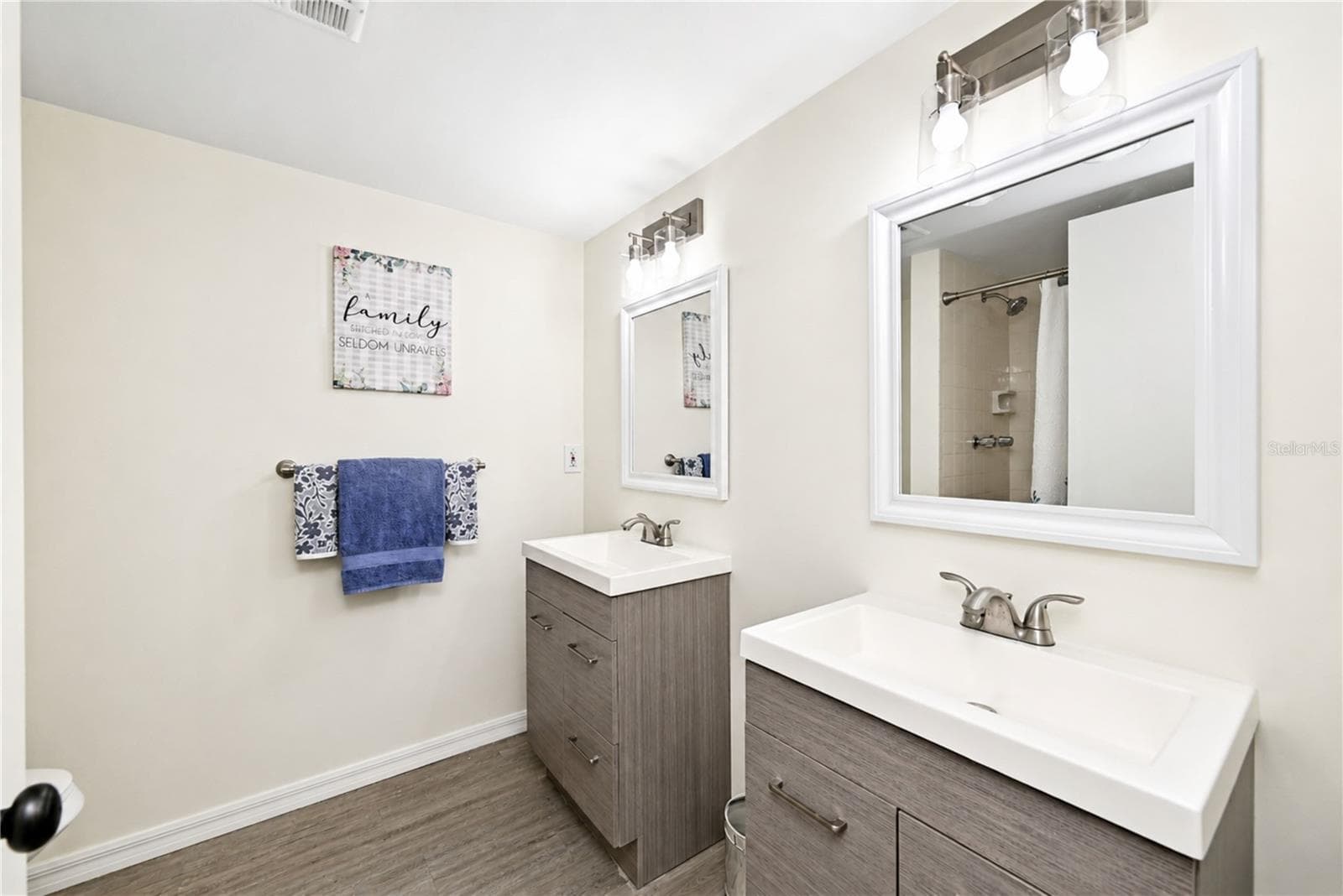 Primary bedroom's updated ensuite bathroom boasts dual vanities and a walk-in shower - 4853 INDEPENDENCE DR, BRADENTON