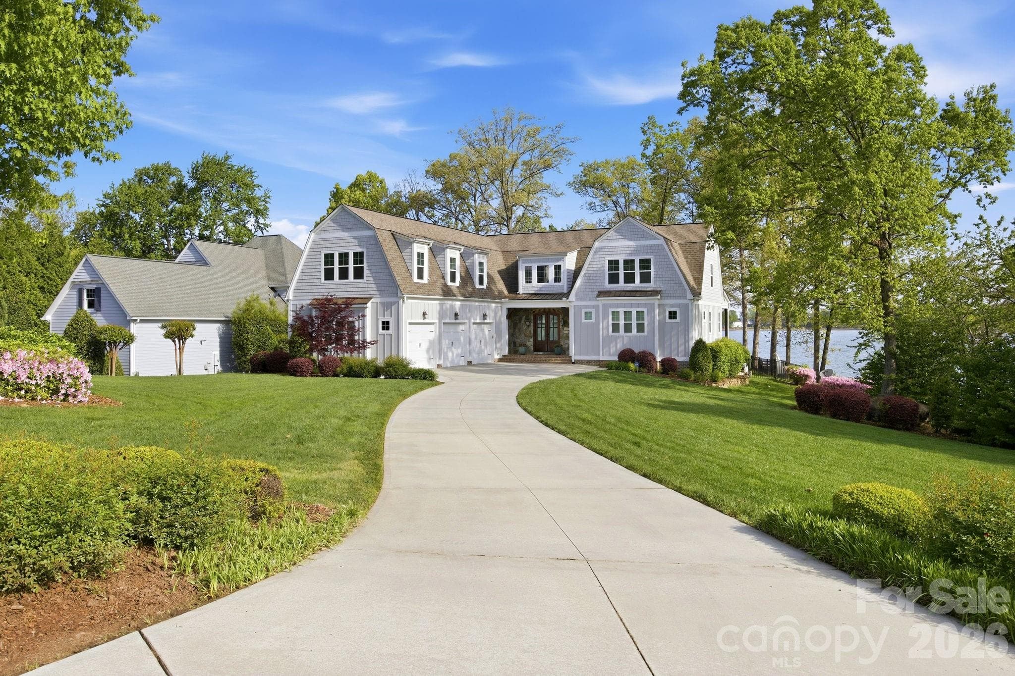 Front exterior showcases a well-maintained lawn, landscaped yard, and inviting covered entry. - Cornelius
