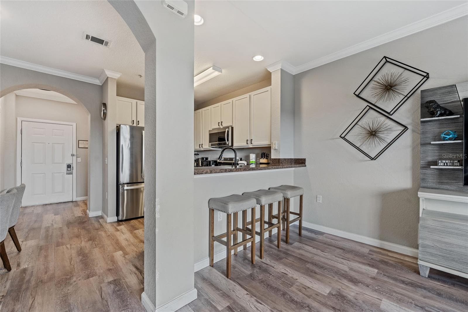 Kitchen and breakfast bar with stools from living area - 14200 AVALON RD #409, WINTER GARDEN