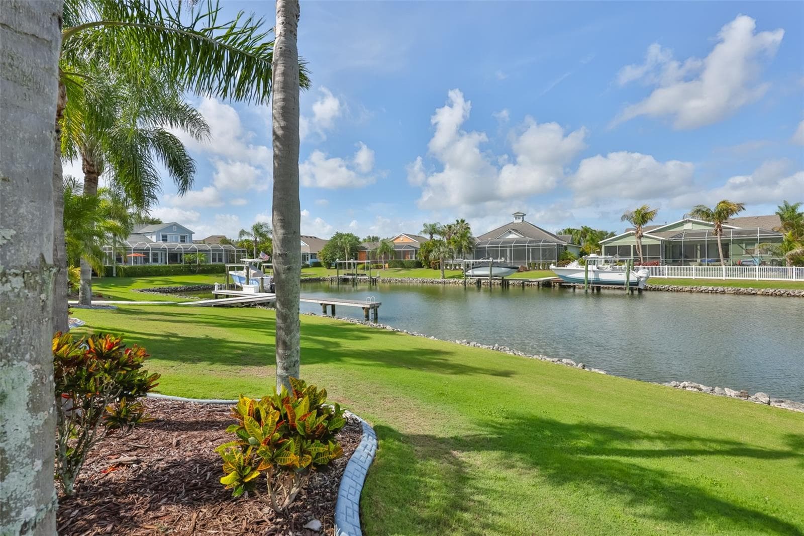grassy lawn behind screened lanai with lovely canal views - 5318 LOON NEST CT, APOLLO BEACH