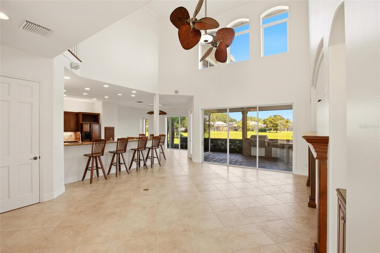 The family room features soaring cathedral ceilings, a fireplace with mantel, and sliding glass doors opening to the lanai, while flowing seamlessly into the kitchen for comfortable everyday living and entertaining. - 8417 LONE EAGLE WAY, SARASOTA