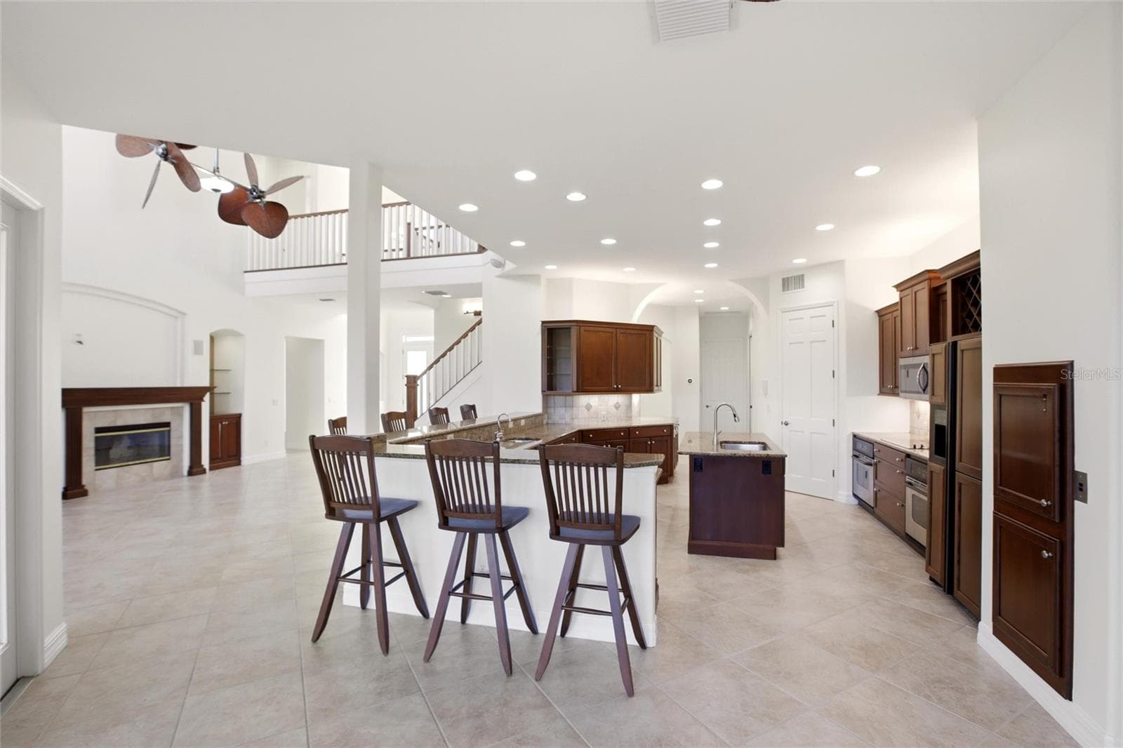 The kitchen offers an extensive breakfast bar and a comfortable casual dining area, along with generous counter space, dual sinks, double ovens, abundant cabinetry, and a spacious walk-in pantry. - 8417 LONE EAGLE WAY, SARASOTA