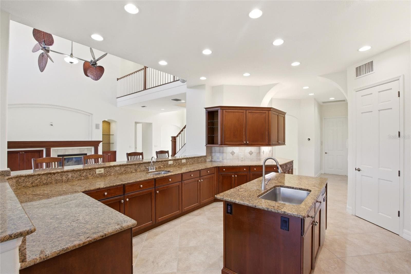 The kitchen offers an extensive breakfast bar and a comfortable casual dining area, along with generous counter space, dual sinks, double ovens, abundant cabinetry, and a spacious walk-in pantry. - 8417 LONE EAGLE WAY, SARASOTA