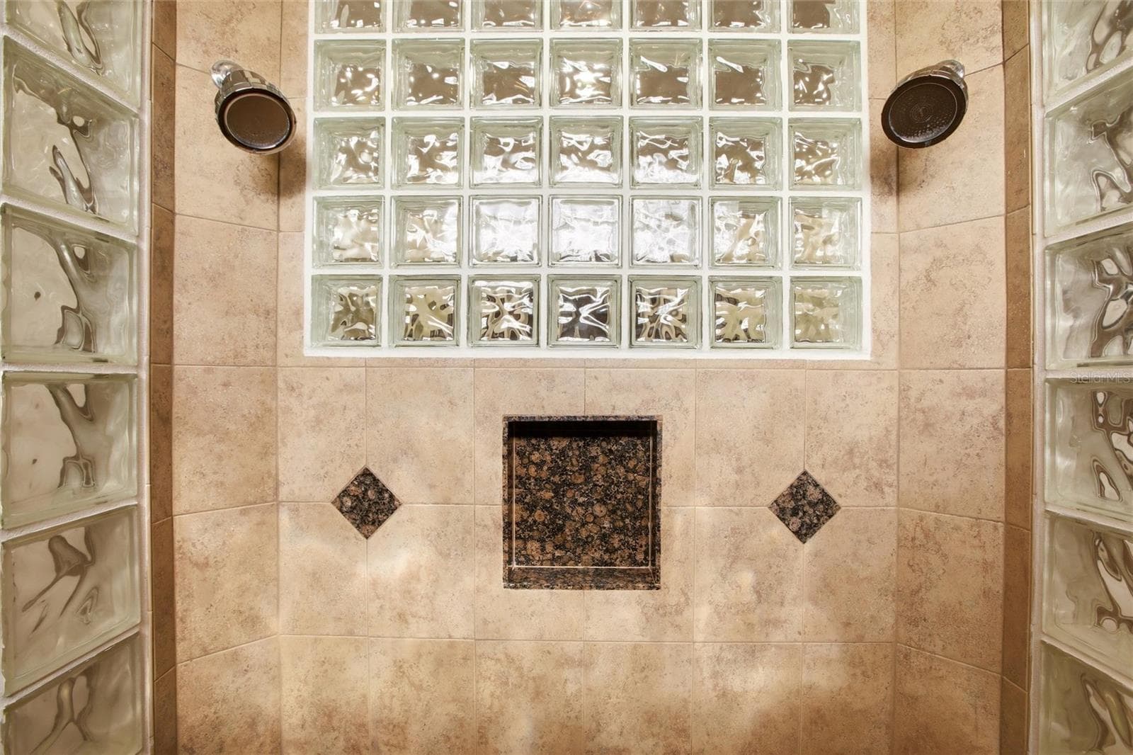 The primary bathroom features a soaking tub, split vanities with dedicated makeup counter space, a spacious walk-in shower with dual shower heads, a private water closet, and dual walk-in closets with custom organization. - 8417 LONE EAGLE WAY, SARASOTA