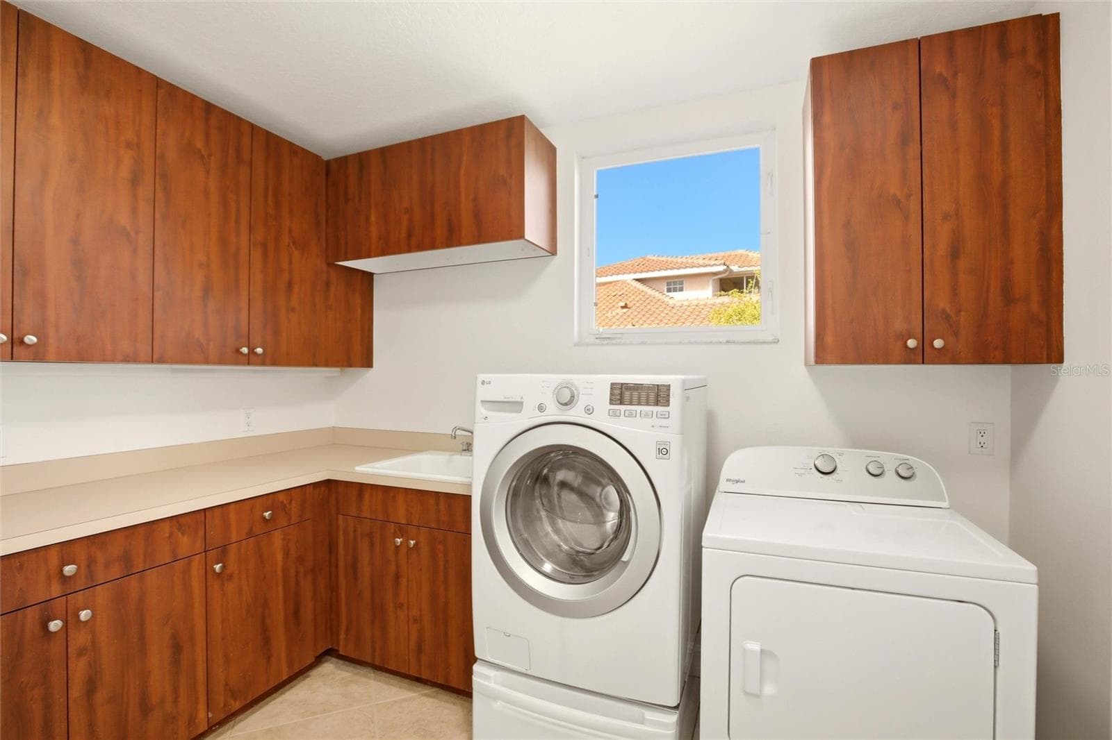 The first-floor laundry room offers abundant cabinetry, a generous folding counter workspace, and a stand-up deep freezer for added convenience and storage. - 8417 LONE EAGLE WAY, SARASOTA