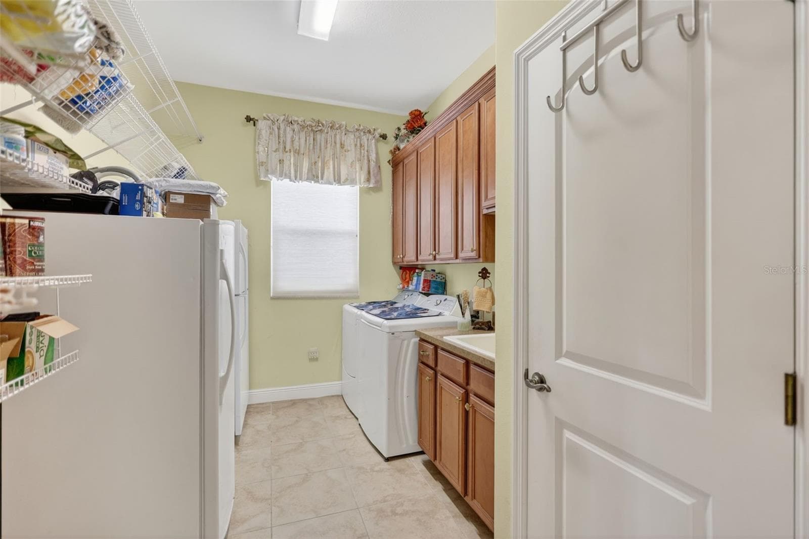 The spacious laundry room offers abundant cabinetry, countertop workspace, and additional storage to keep daily routines organized. - 1210 408TH CT E, MYAKKA CITY