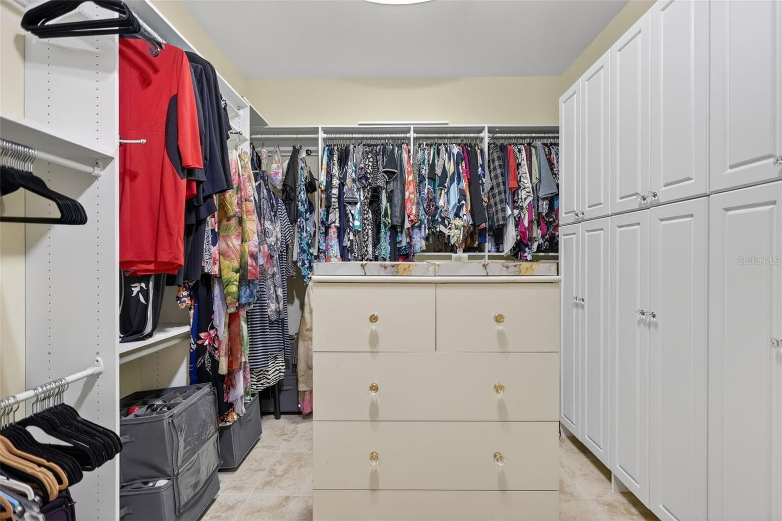 The custom-designed primary closet provides exceptional organization with built-in cabinetry, extensive hanging space, and integrated drawer storage. - 1210 408TH CT E, MYAKKA CITY