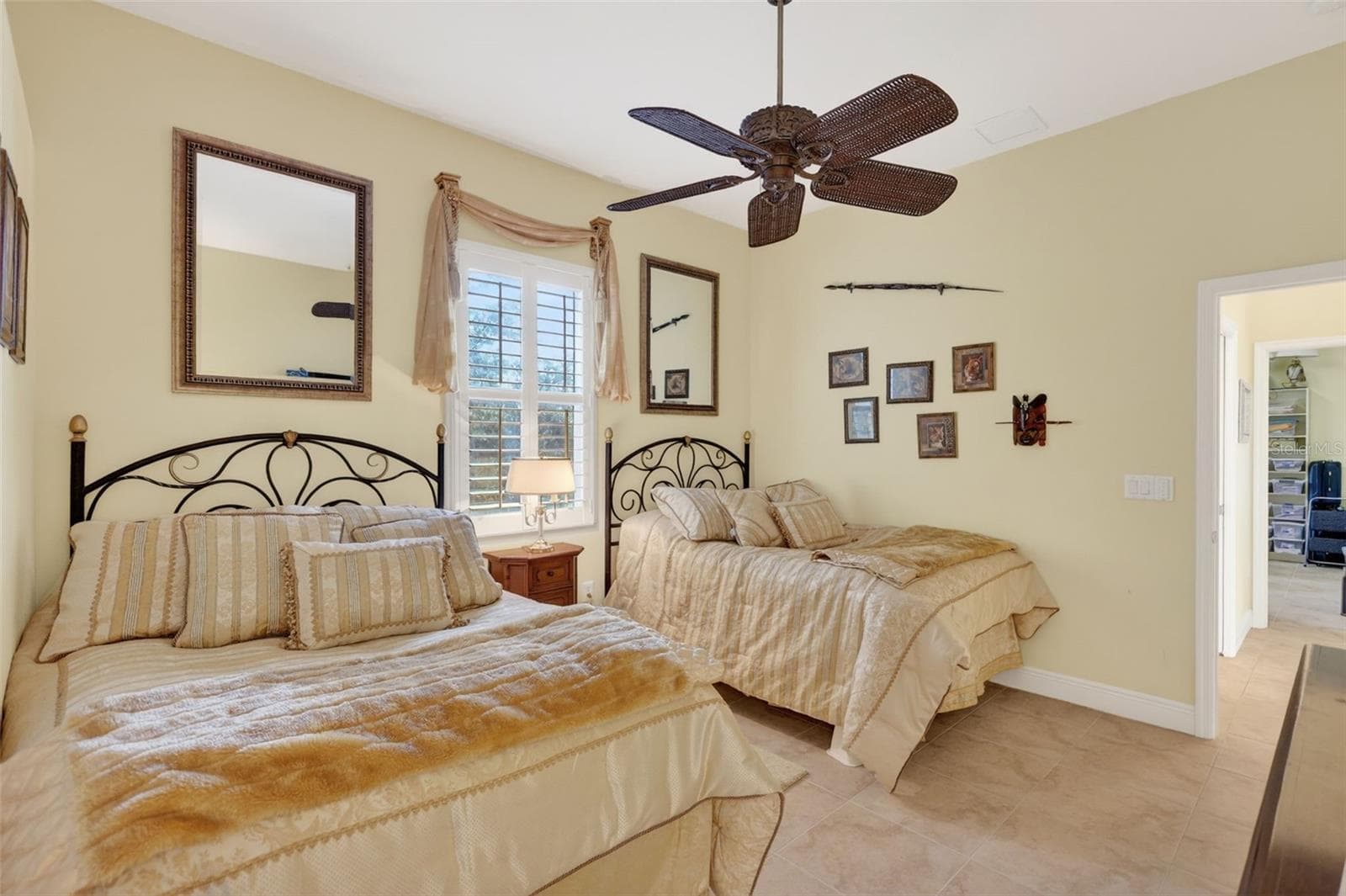 The spacious guest bedroom comfortably accommodates multiple sleeping arrangements while offering generous closet space and charming architectural details. - 1210 408TH CT E, MYAKKA CITY