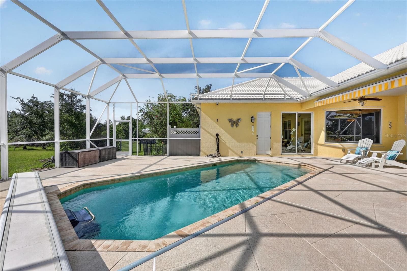 The screened lanai and pool area provide a private oasis with generous deck space, scenic views, and exceptional opportunities for relaxation and entertaining. - 1210 408TH CT E, MYAKKA CITY