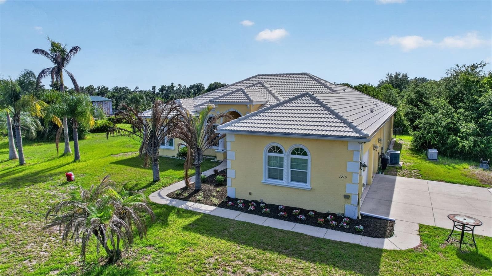 The home's elegant Mediterranean-inspired architecture, tile roof, and lush landscaping create exceptional curb appeal on this private multi-acreage homesite. - 1210 408TH CT E, MYAKKA CITY