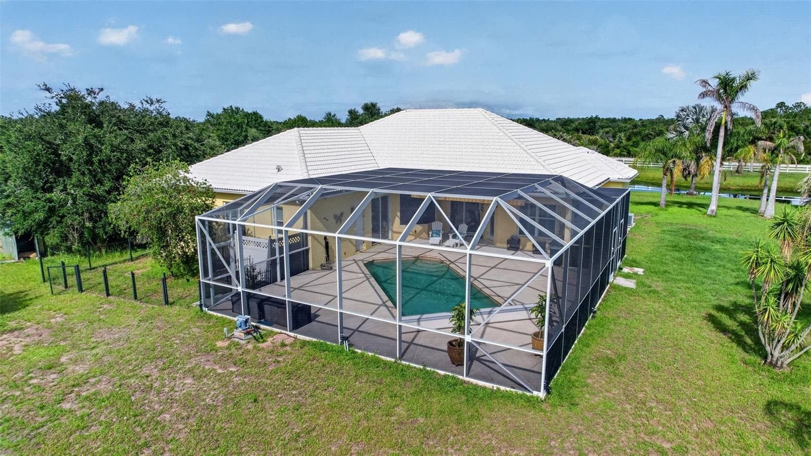 The oversized screened enclosure and resort-style pool create an extraordinary outdoor living environment with abundant space for entertaining and recreation. - 1210 408TH CT E, MYAKKA CITY