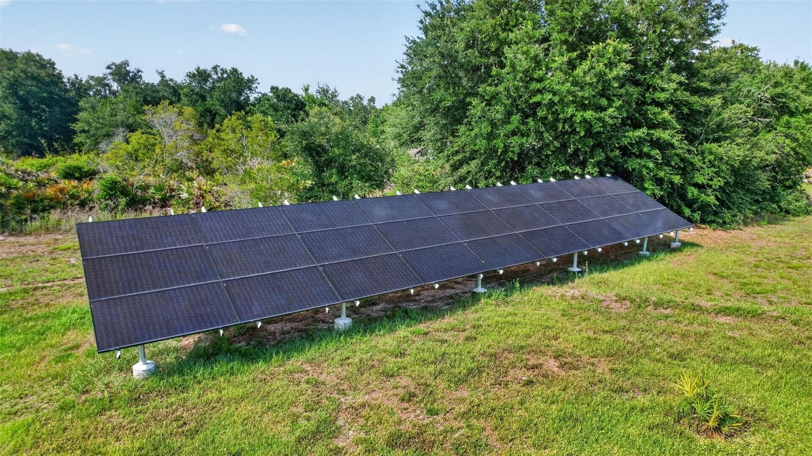 The owned ground-mounted solar array helps maximize energy efficiency while complementing the property's self-sufficient lifestyle appeal. - 1210 408TH CT E, MYAKKA CITY