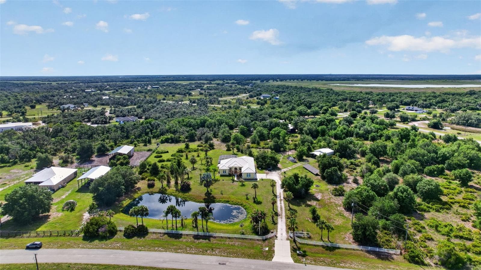 Beautifully positioned behind the private pond and gated entrance, the residence offers exceptional curb appeal and a serene waterfront setting. - 1210 408TH CT E, MYAKKA CITY