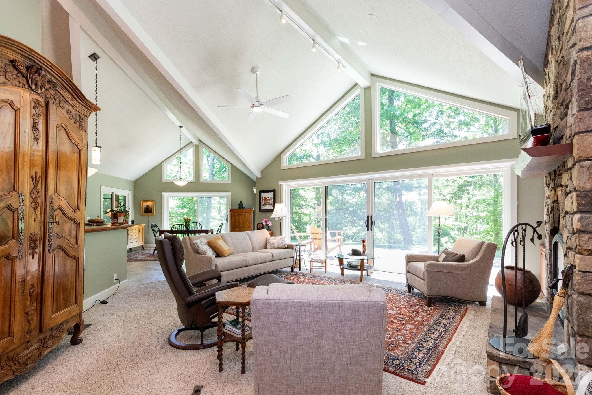 Light-filled great room featuring vaulted ceilings, dramatic wall of windows, and seamless indoor-outdoor flow. The open layout offers a warm yet refined atmosphere ideal for gathering and entertaining. - 29 Gardner Drive, Asheville