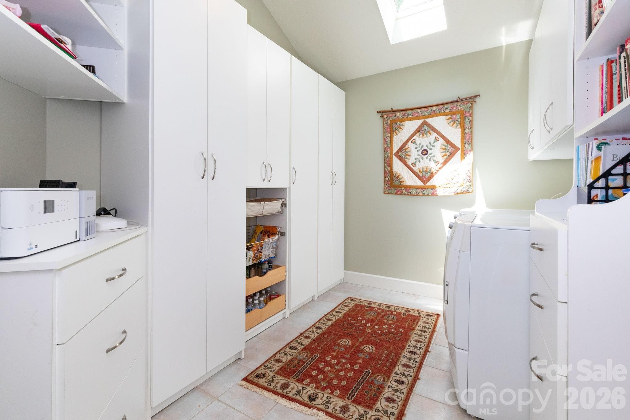 Well-designed laundry and utility space with extensive cabinetry, storage solutions, pantry, skylight, and functional workspace for effortless organization. - 29 Gardner Drive, Asheville